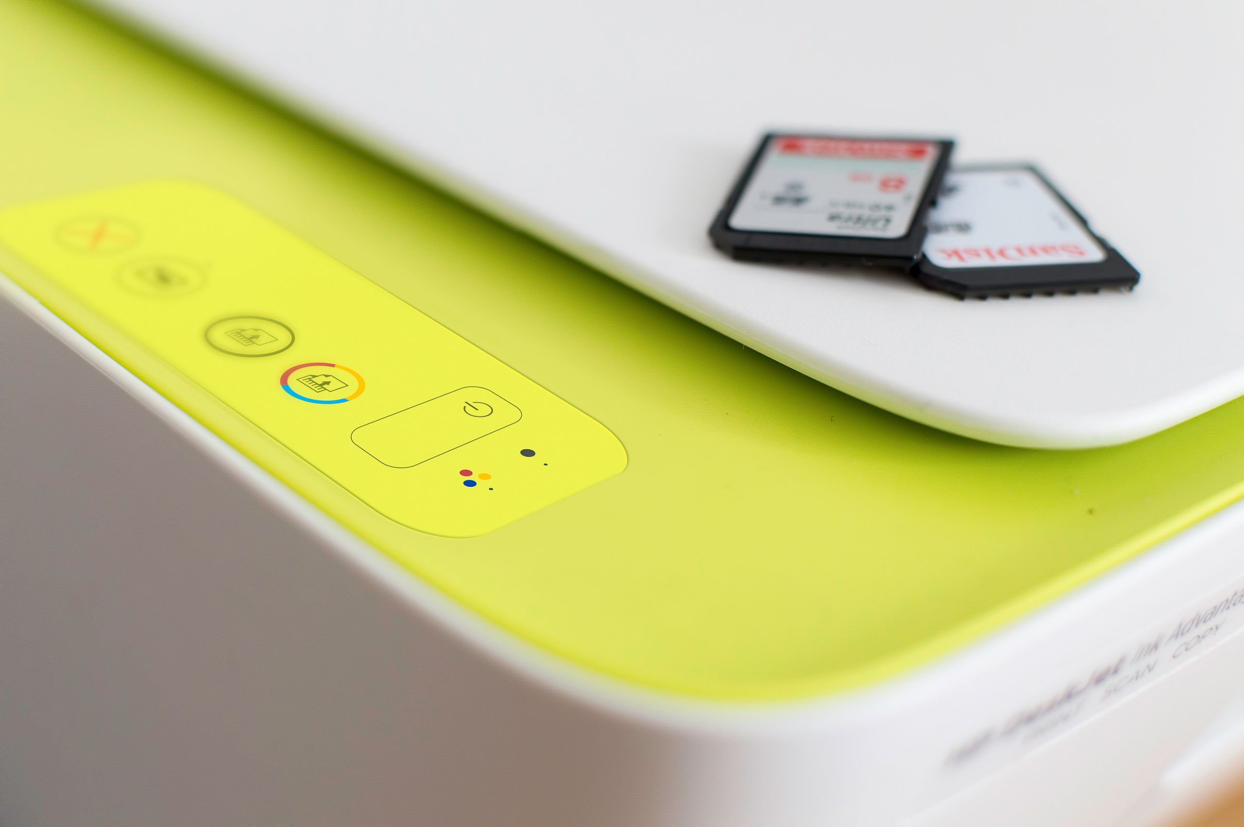 Detailed shot of a printer's control panel with SD cards on top, highlighting modern tech.