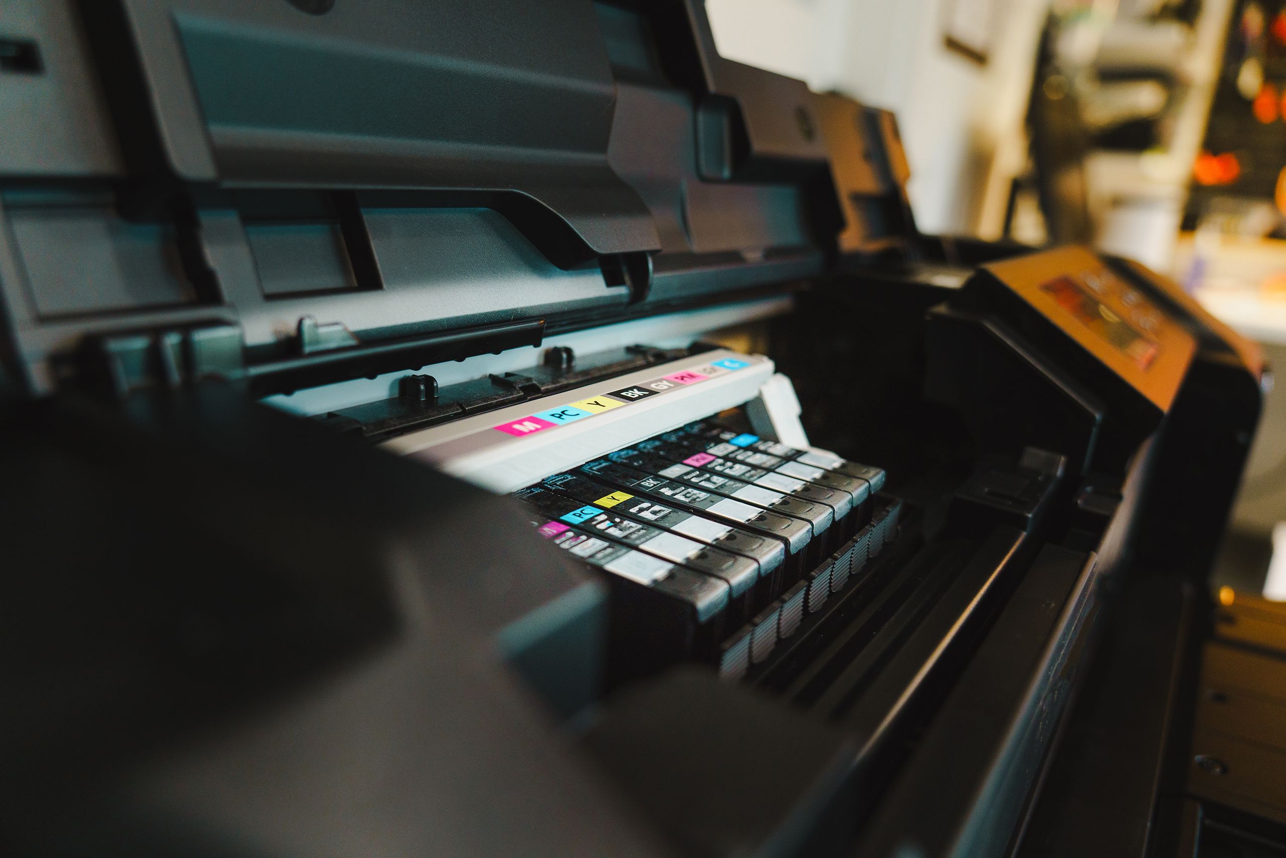 Detailed view of ink cartridges inside a digital inkjet printer in an office setting.